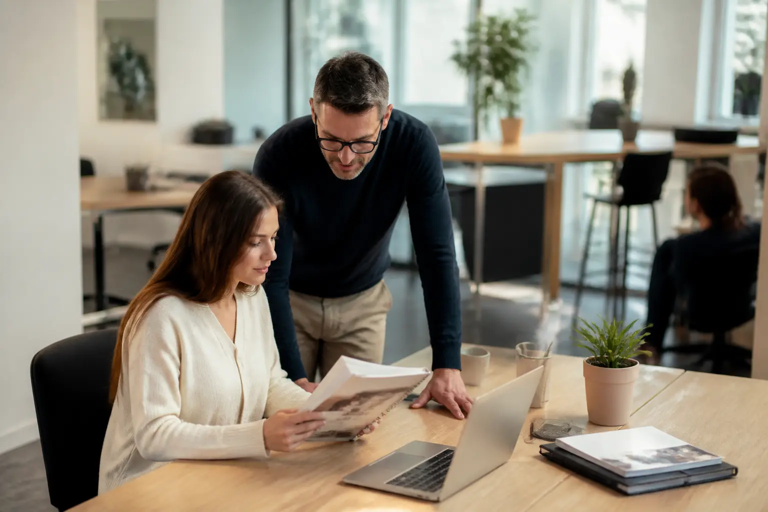 Employé en onboarding avec livret d'accueil, manager à proximité, bureau moderne, ambiance rassurante et professionnelle
