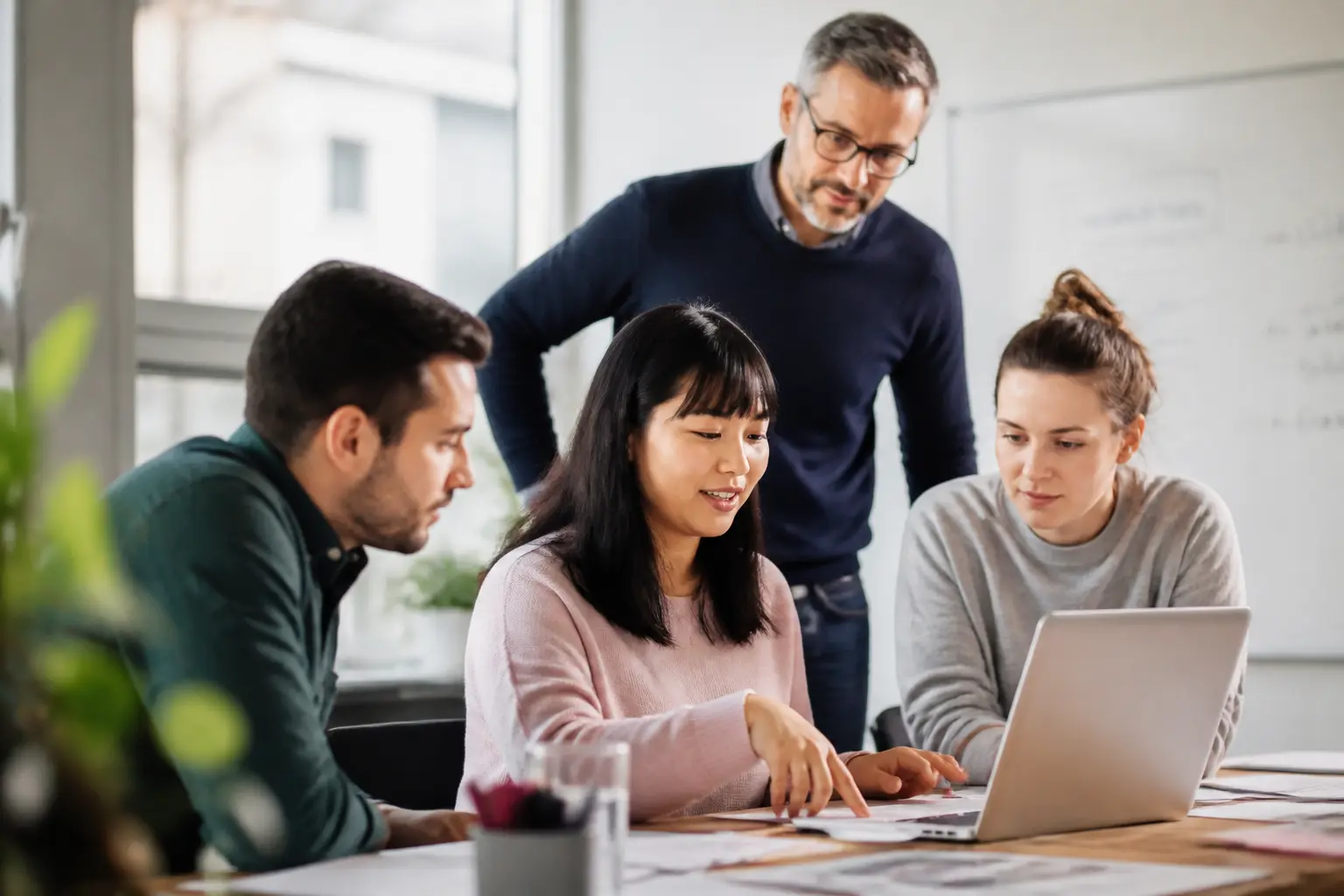 Montée en compétence d’une équipe en bureau moderne, manager guidant des employés sur des tâches réelles
